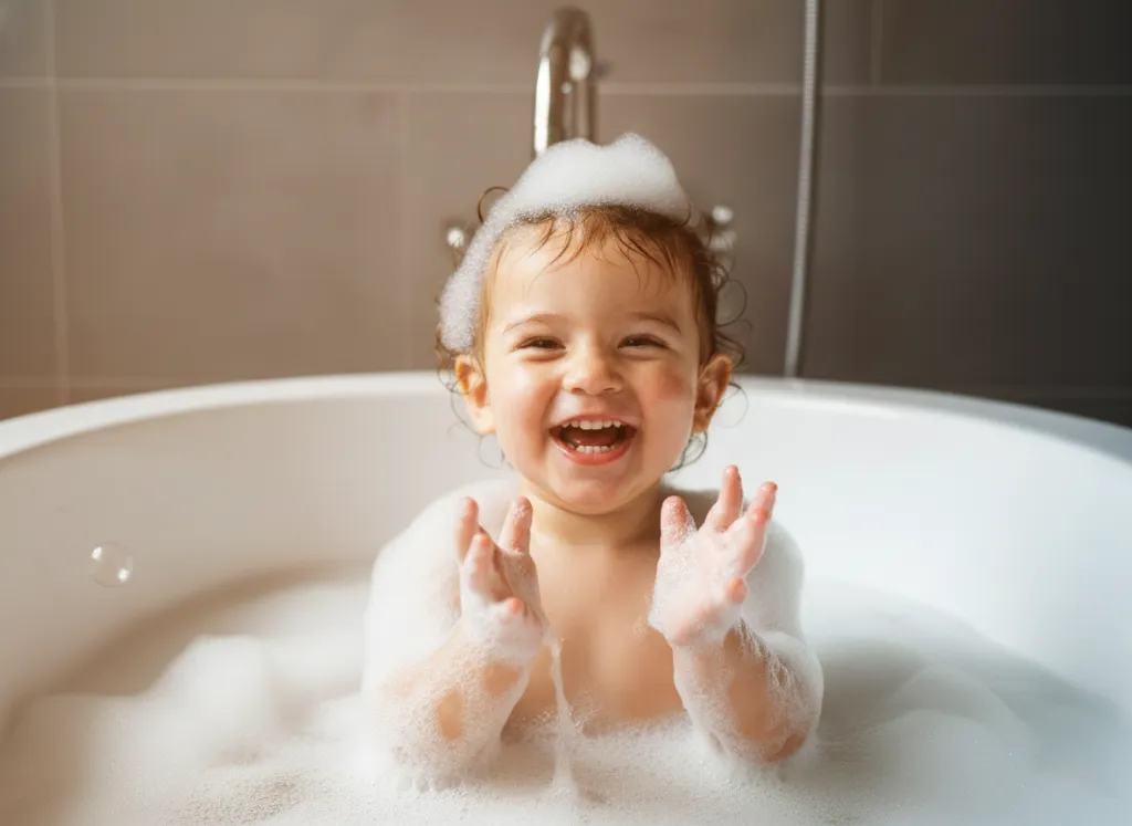 bebê sorridente ensaboado na banheira